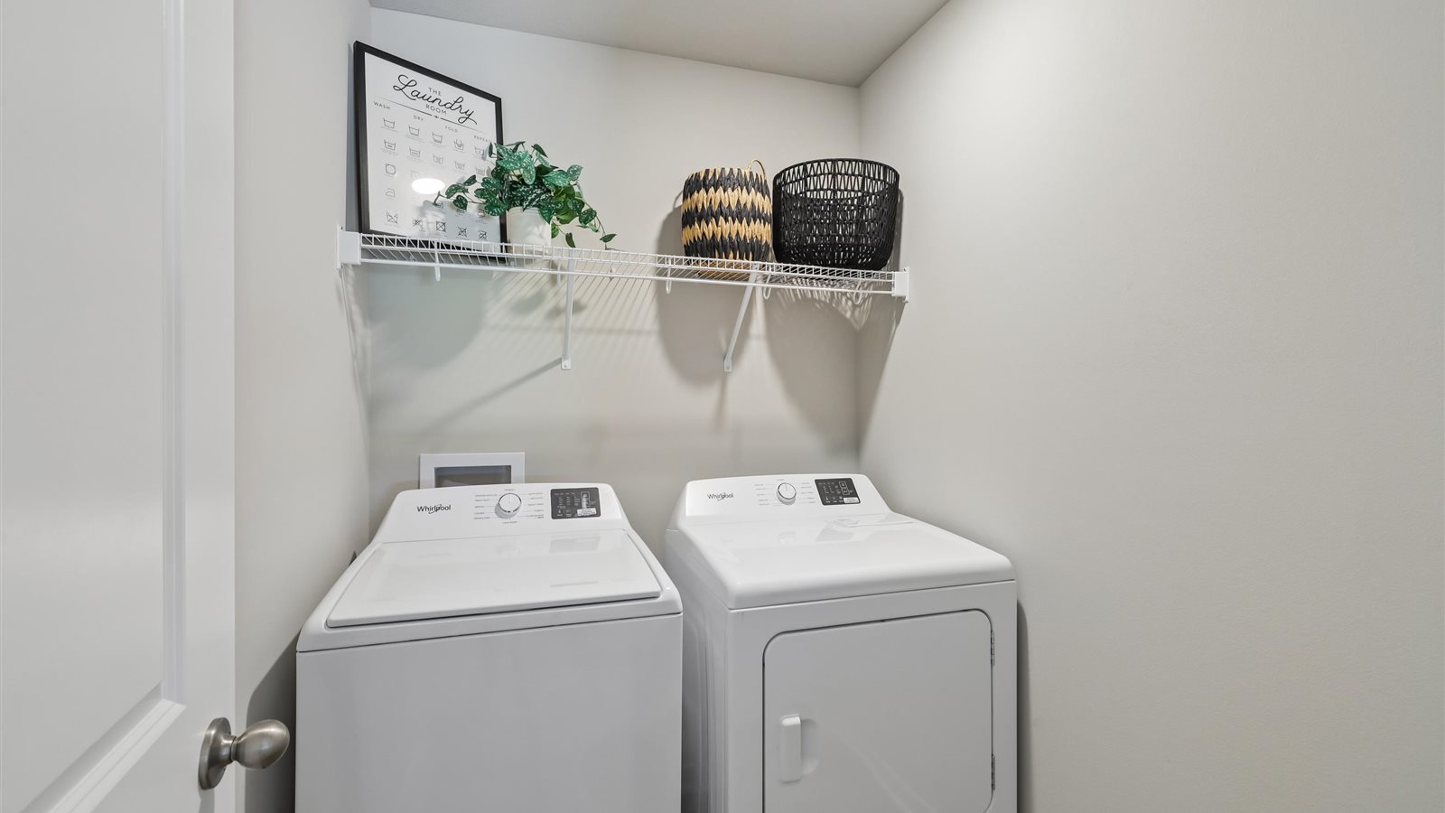 Dedicated laundry room with built-in shelving and utility connections.