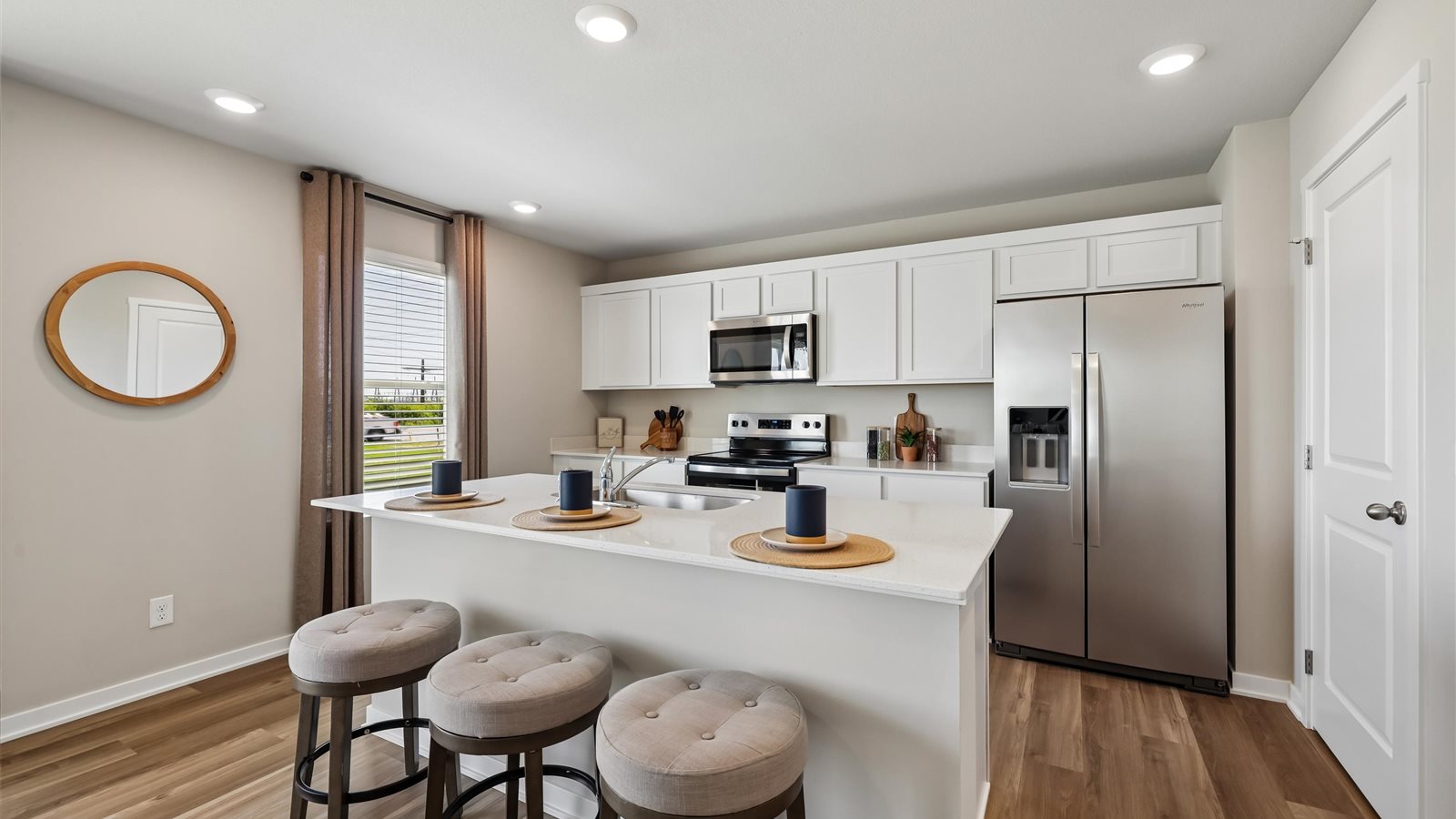 Kitchen with stainless steel appliances, quartz countertops, and white cabinetry