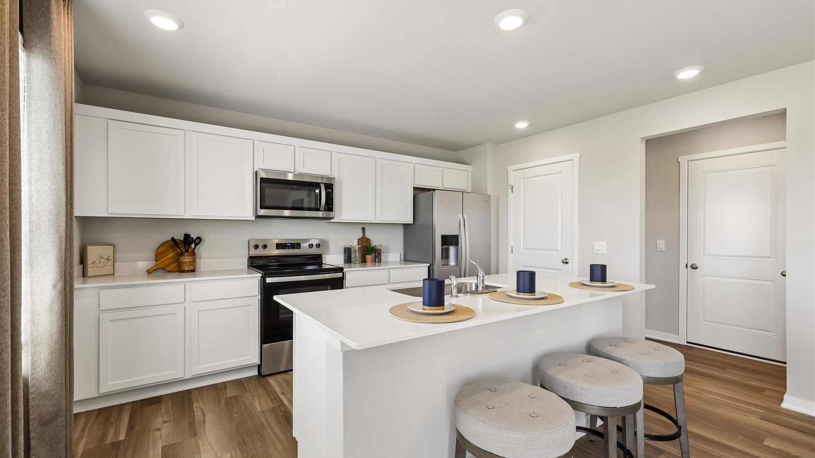 Kitchen with stainless steel appliances, quartz countertops, and white cabinetry