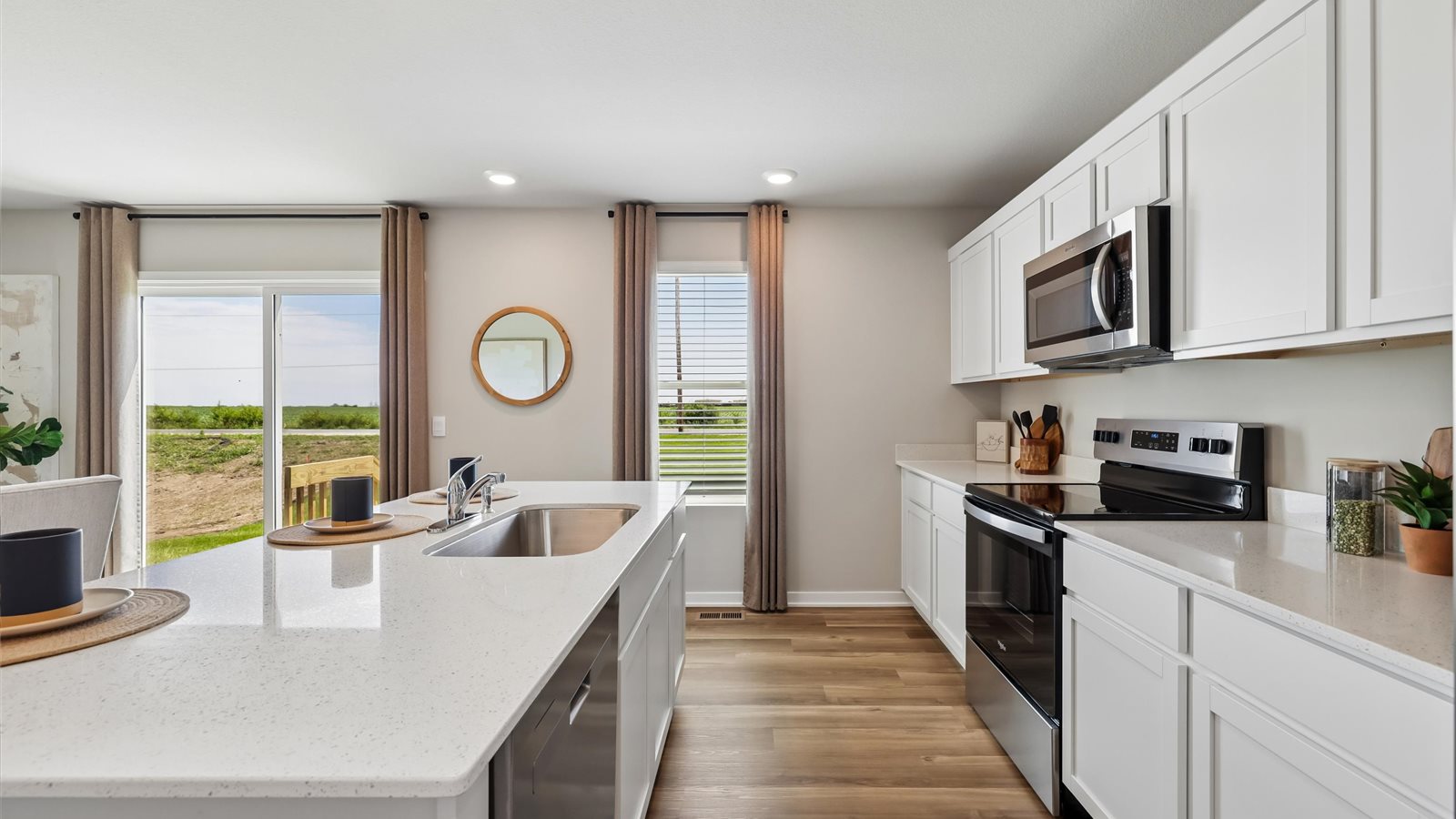Kitchen with stainless steel appliances, quartz countertops, and white cabinetry