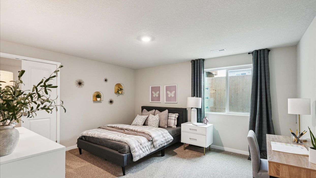Private lower-level bedroom with natural light and functional storage space.