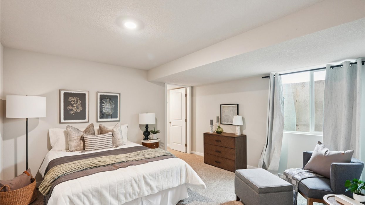 Private lower-level bedroom with natural light and functional storage space.