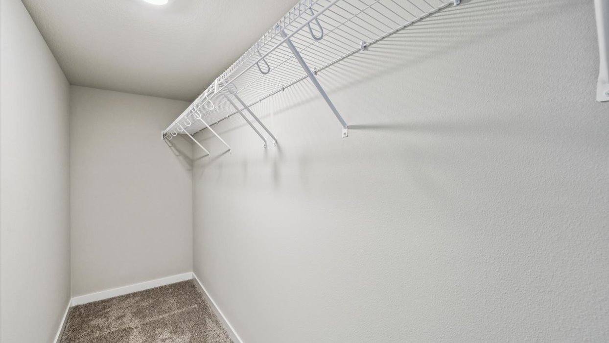 Private lower-level bedroom with natural light and functional storage space.