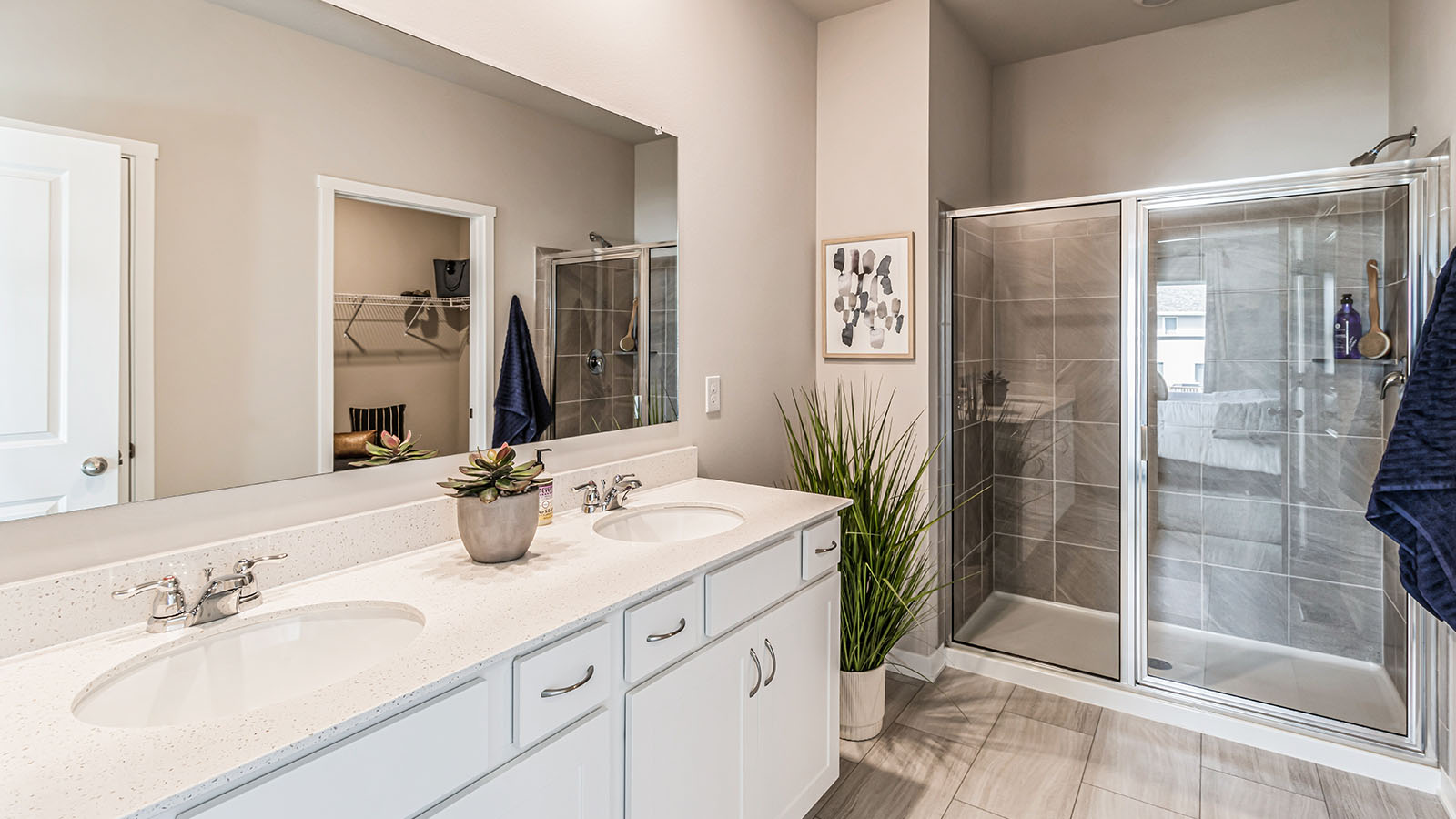 Spacious primary bathroom featuring dual vanities, modern fixtures, and a walk-in shower.