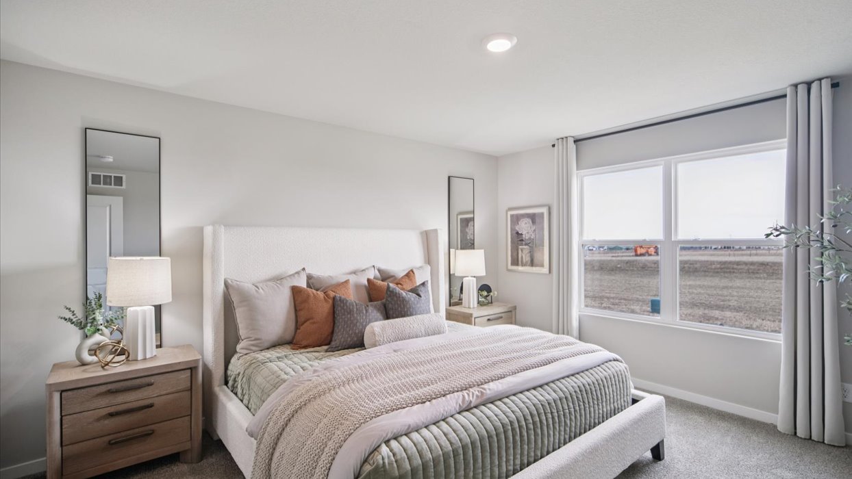 primary bedroom with large window and bed with nightstands