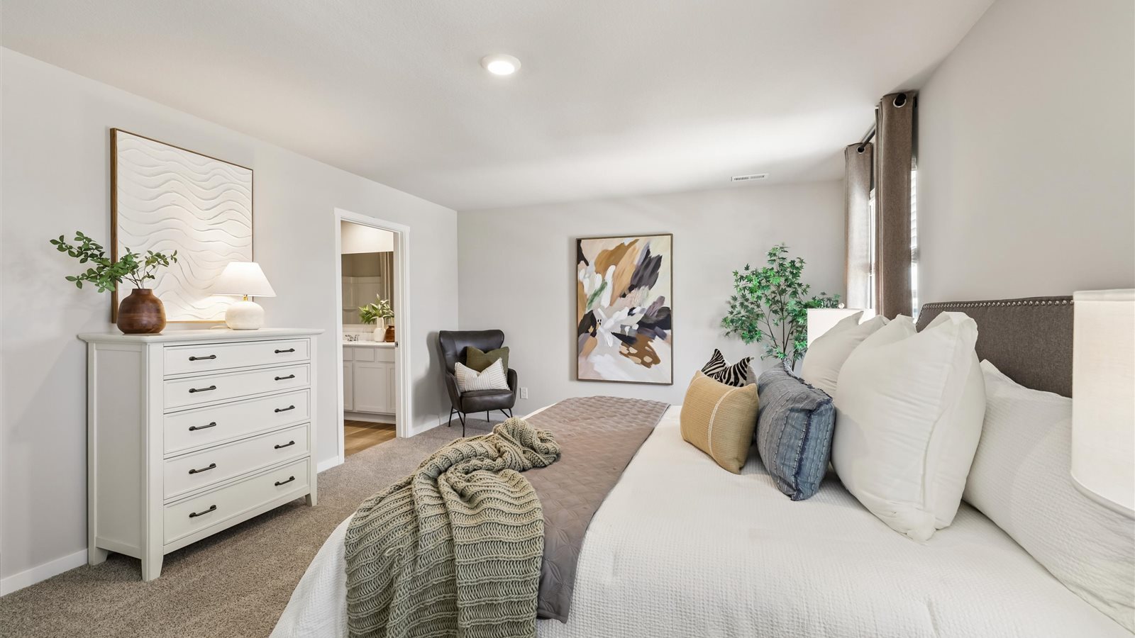Spacious primary suite with natural light, attached bathroom, & walk in closet