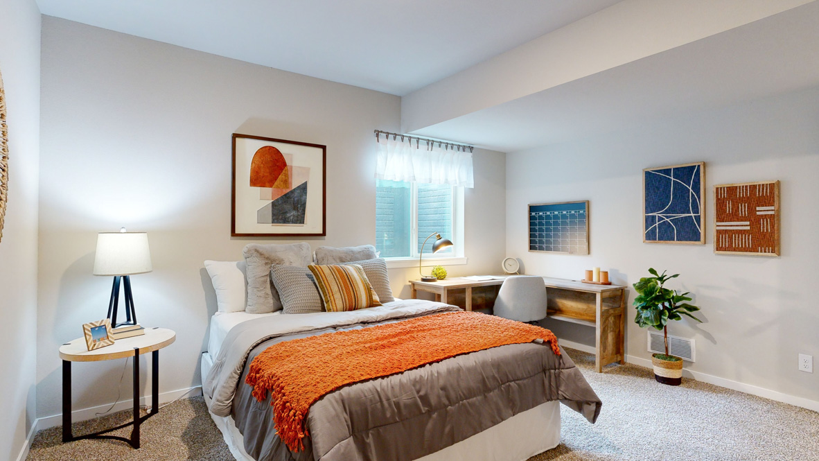 Private lower-level bedroom with natural light and functional storage space.