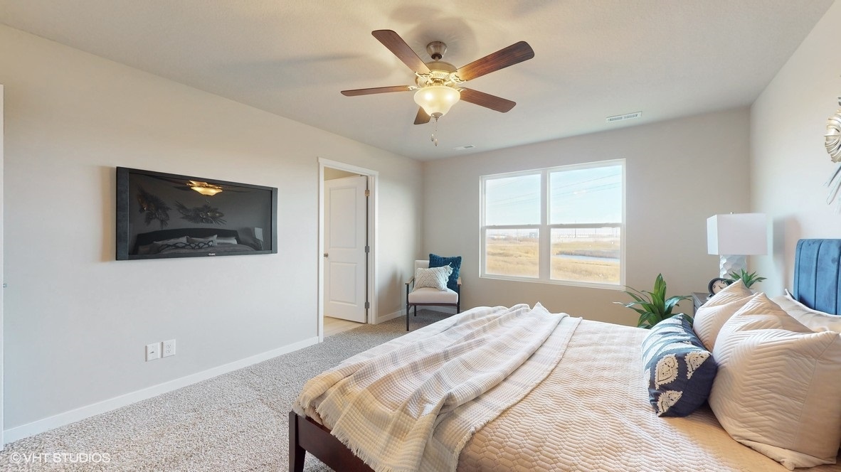 bright primary bedroom with fan