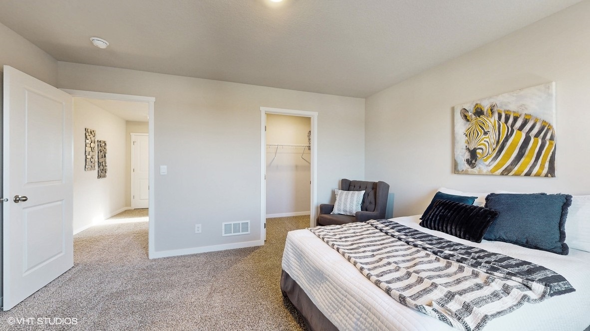 first bedroom with white bed and view of closet