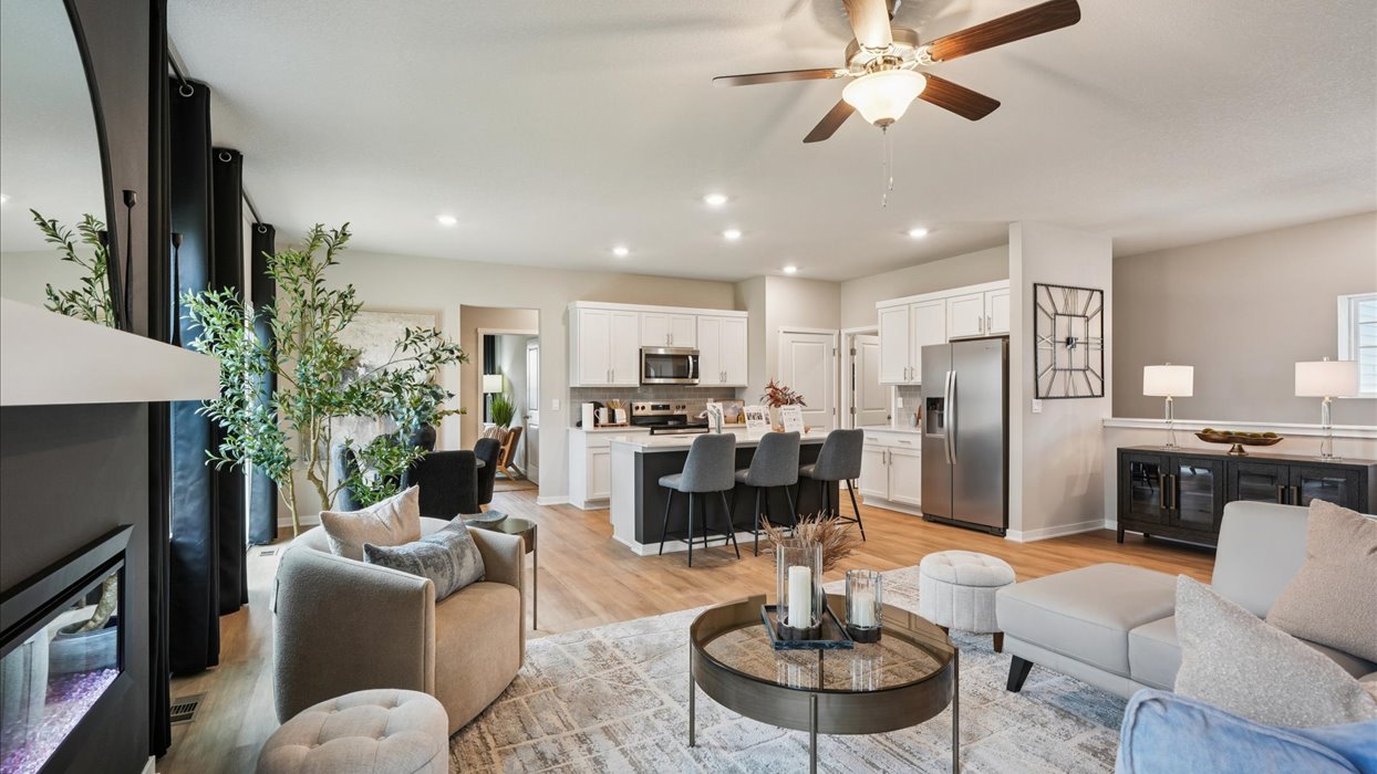 bright living room with couch and coffee table and view of white kitchen