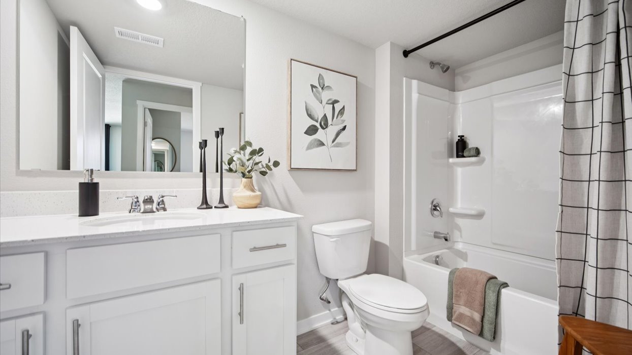 Family full bathroom 2 with vanity, mirror, cabinetry, and tub-shower combination.