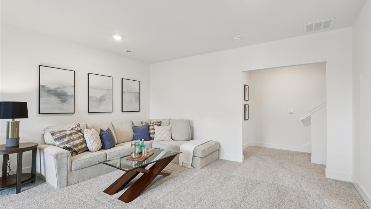 finished basement with grey couch and artwork