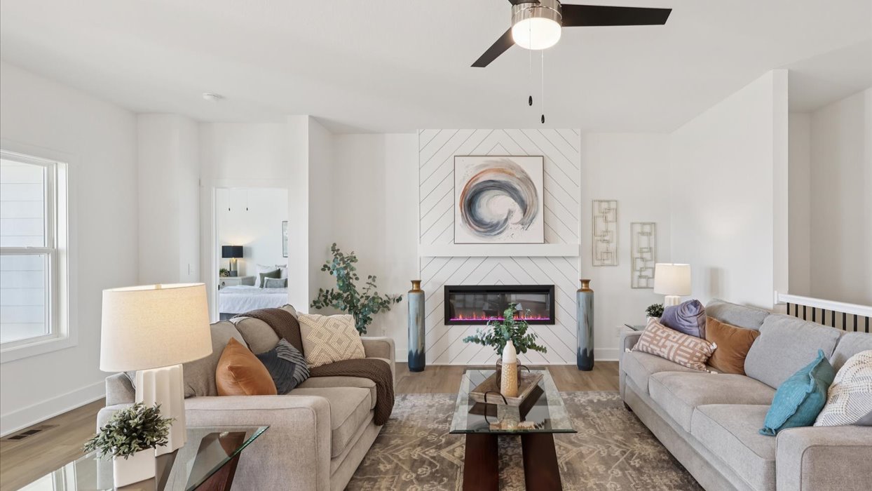 living room with ceiling fan and grey couches
