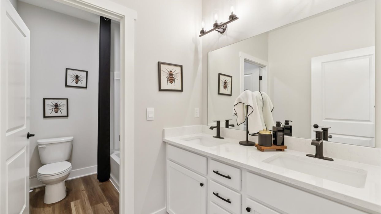 second bathroom with large mirror and dual sinks