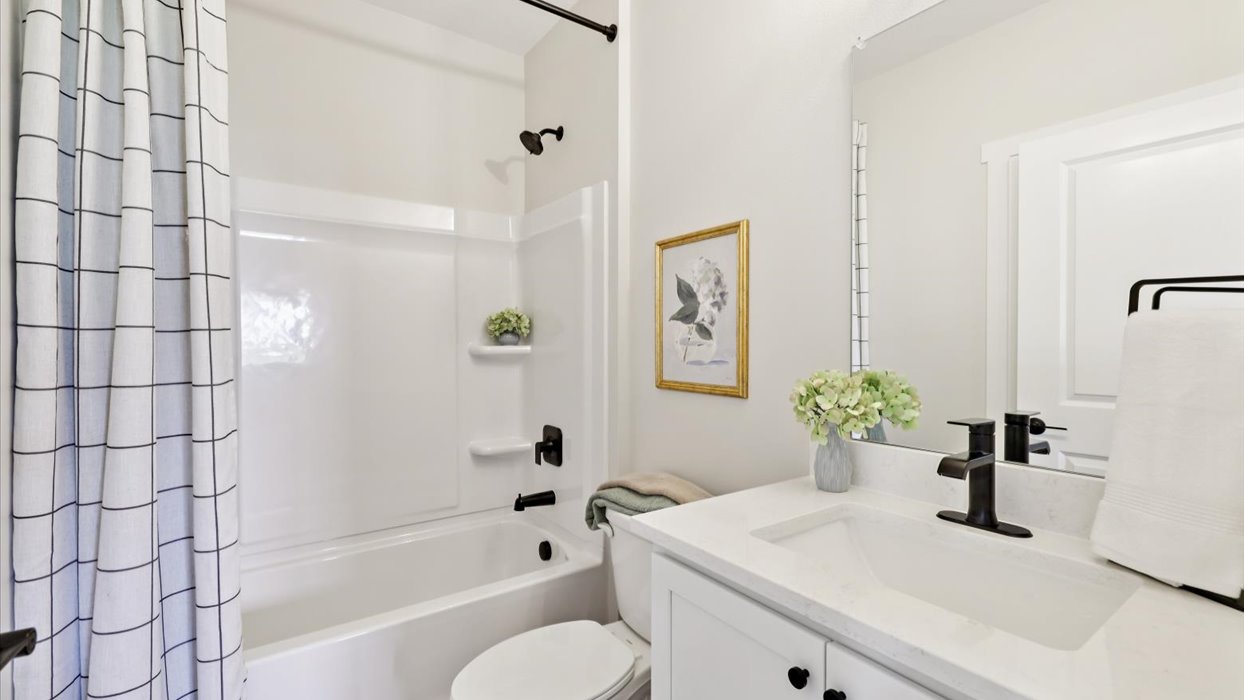 third bathroom with mirror and tub and shower