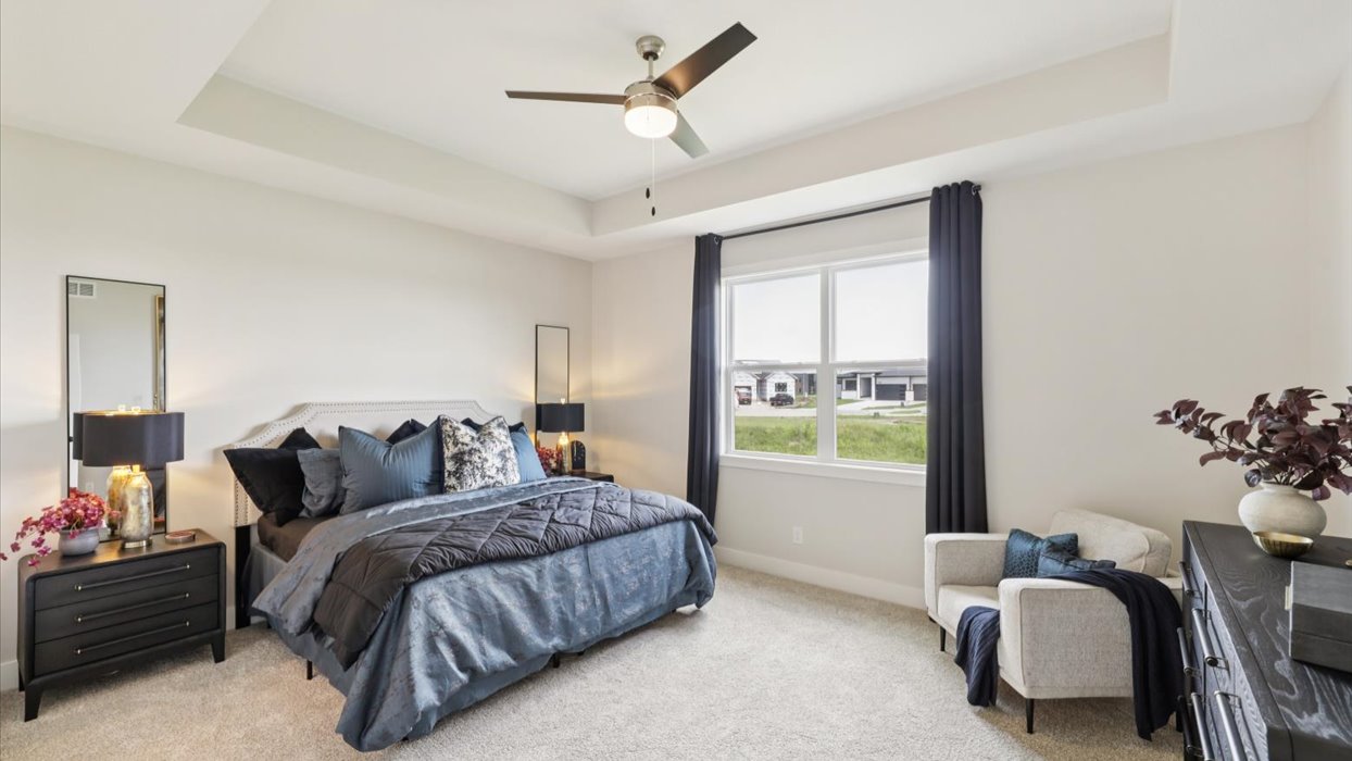 primary bedroom with large window and blue bed