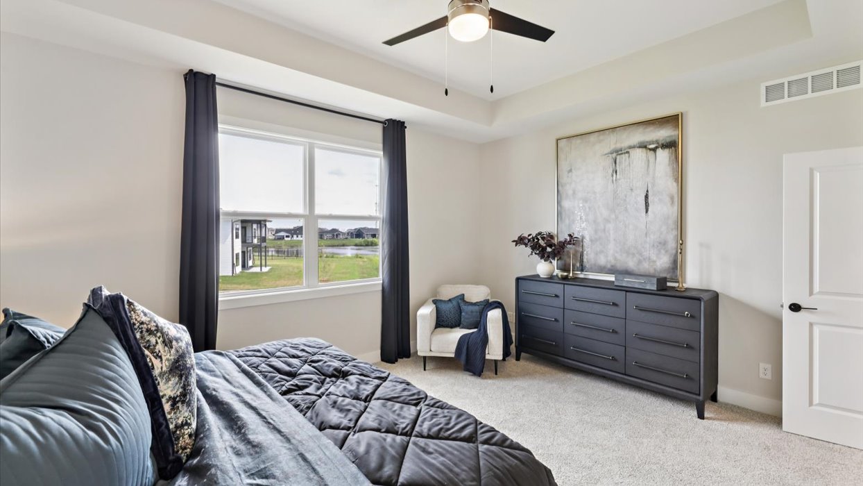 primary bedroom with ceiling fan and dresser