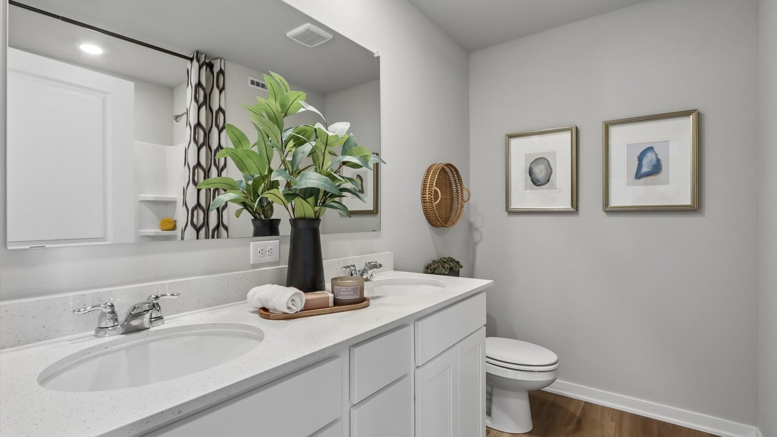 Spacious primary bathroom featuring dual vanities, modern fixtures, and a walk-in shower.