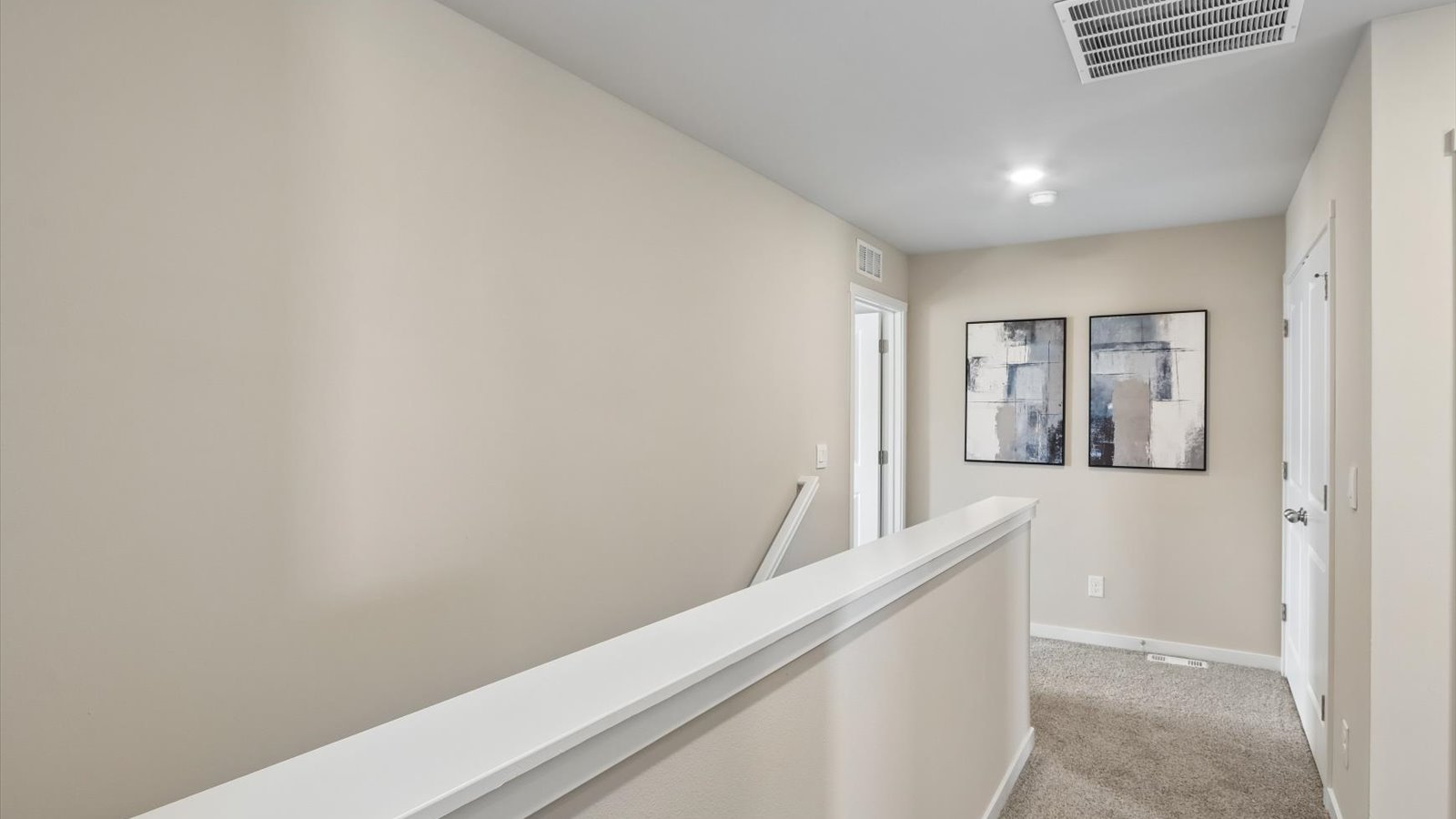 Open landing at the top of the stairs with room for a table and decorative accents.