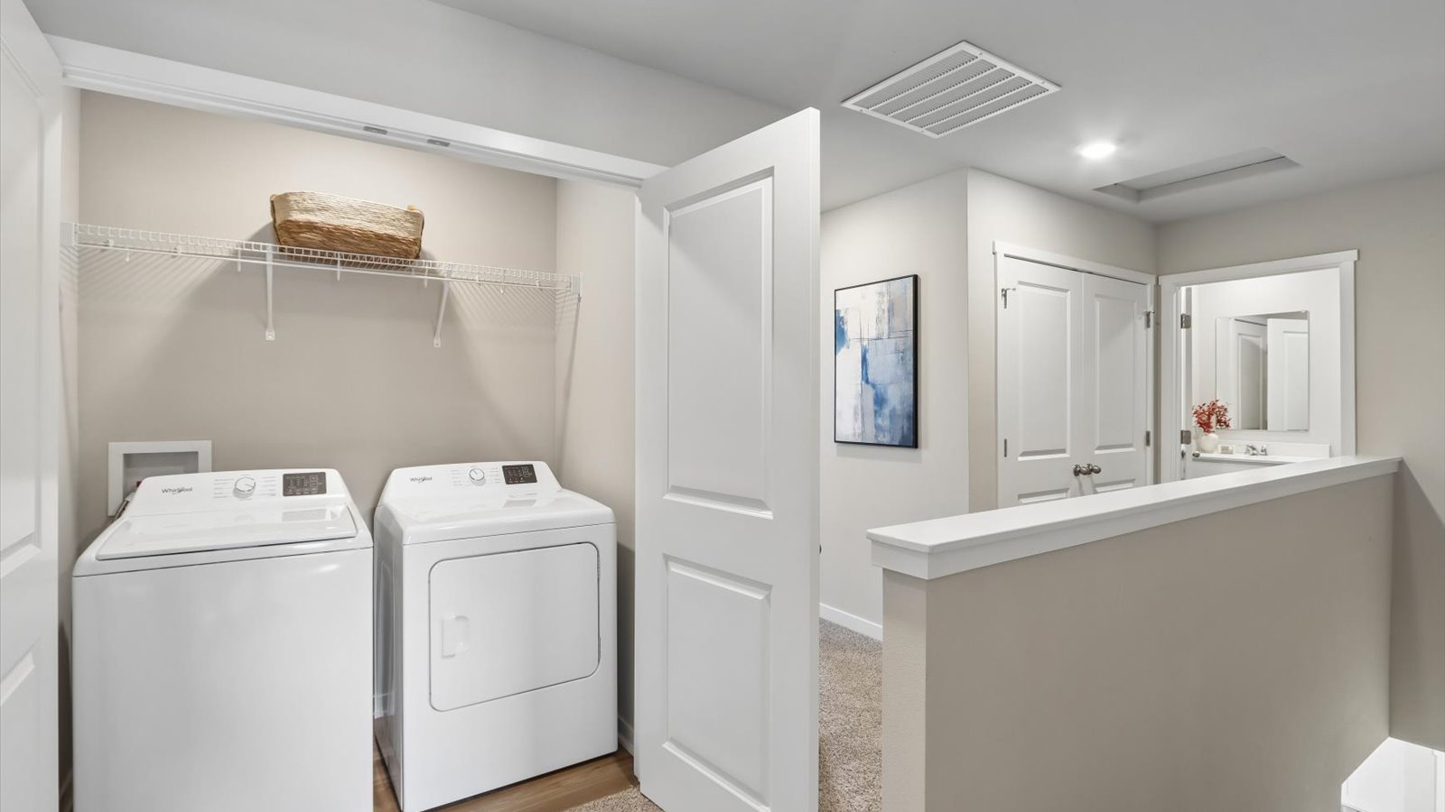 Cozy laundry space with natural light, a washer and dryer, and shelving for supplies.