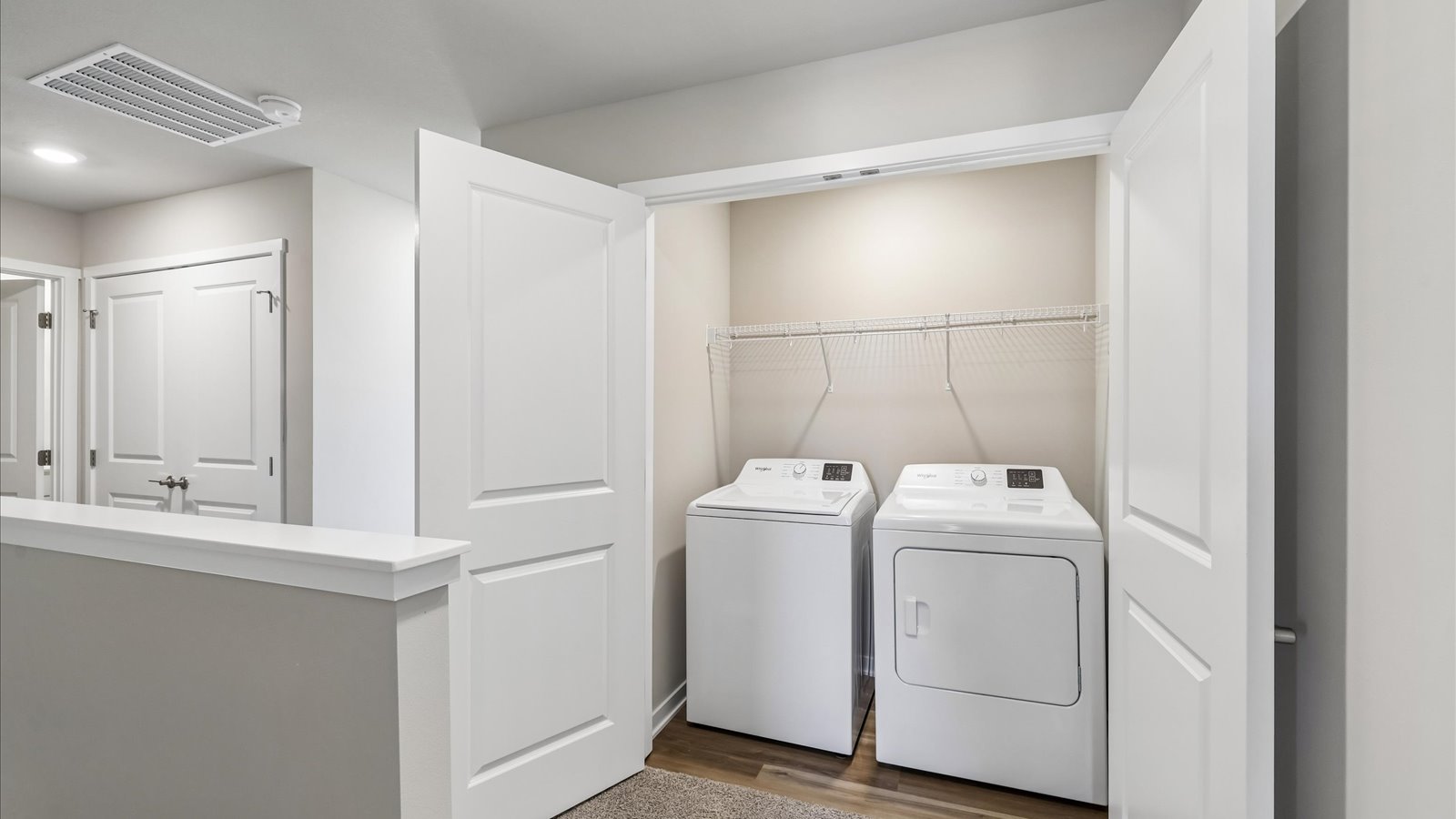 Cozy laundry space with natural light, a washer and dryer, and shelving for supplies.