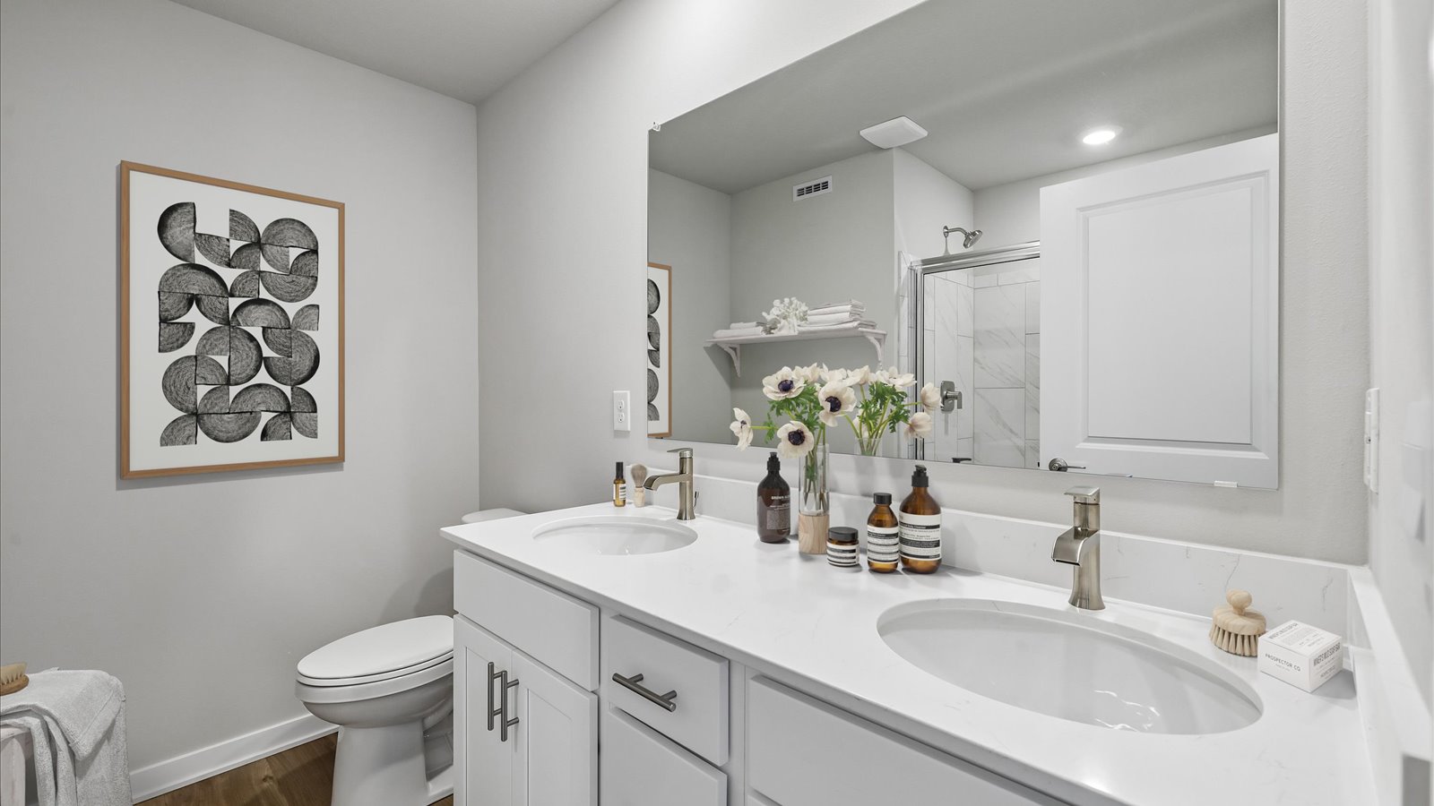 Spacious primary bathroom featuring dual vanities, modern fixtures, and a walk-in shower.