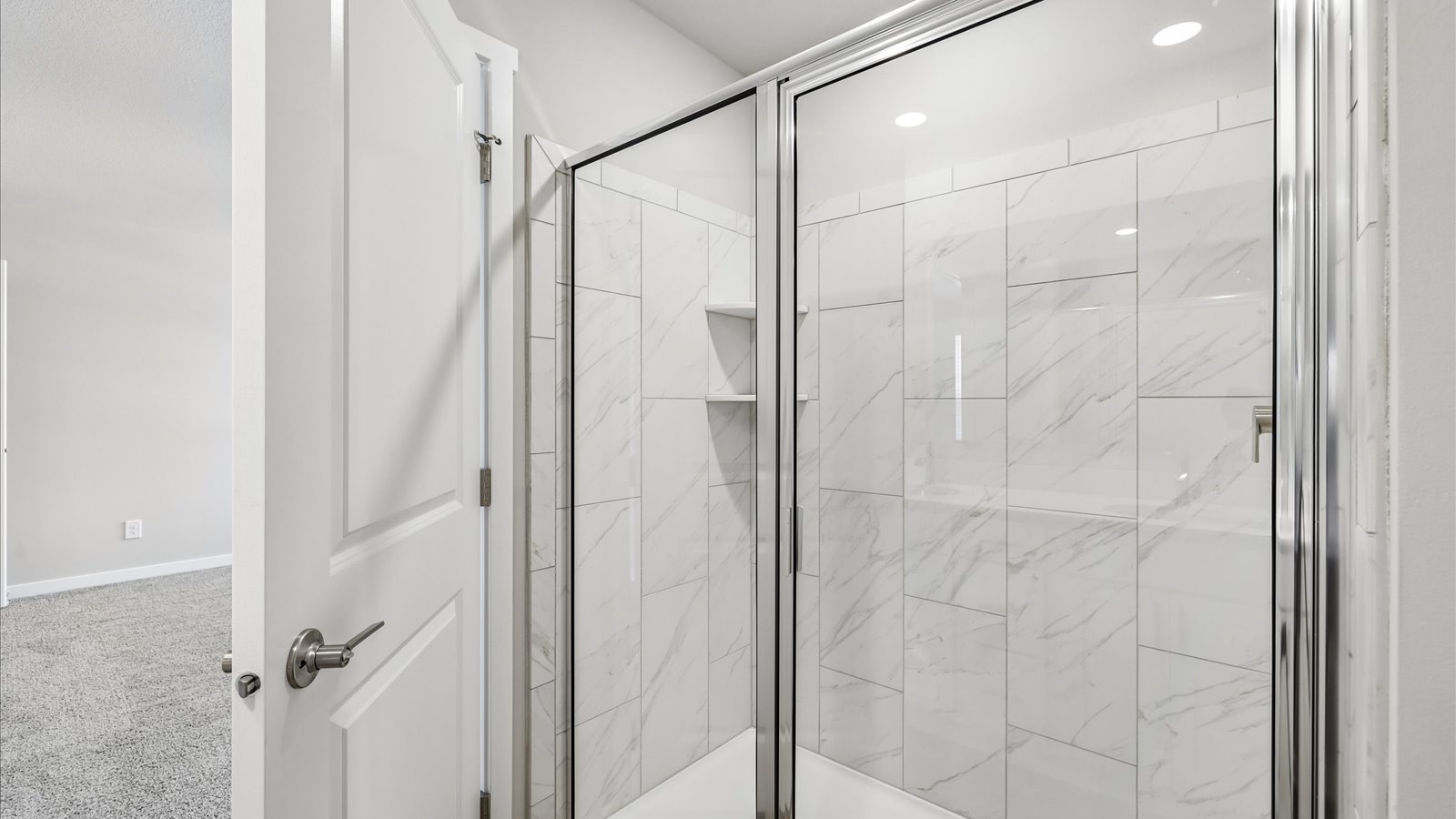 Spacious primary bathroom featuring dual vanities, modern fixtures, and a walk-in shower.