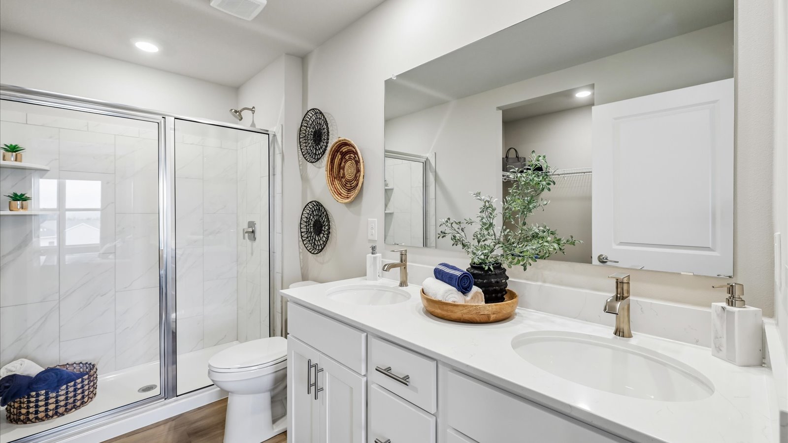 Spacious primary bathroom featuring dual vanities, modern fixtures, and a walk-in shower.