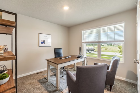 Bedroom staged as office with desk and chairs