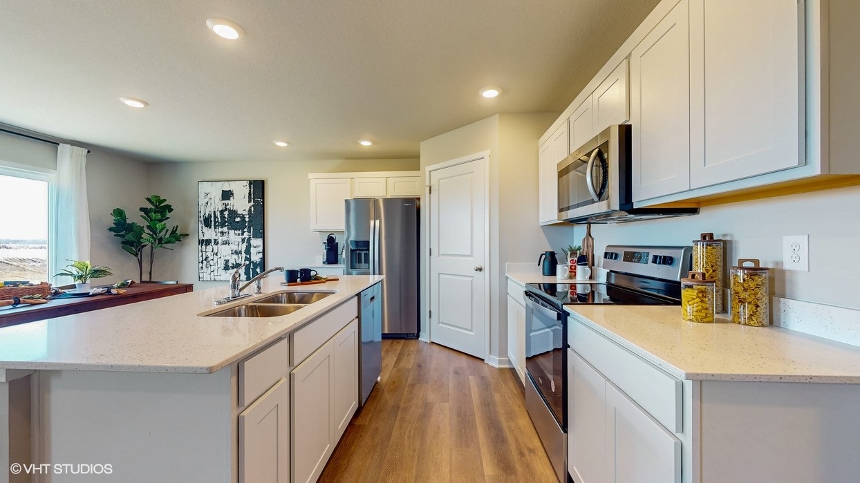 Kitchen with large walk in pantry and quartz countertops.