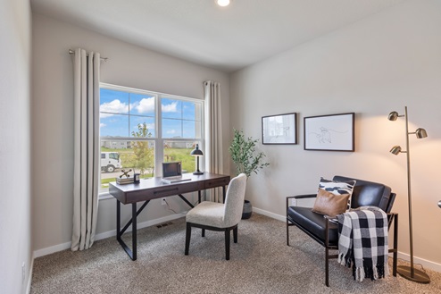Third bedroom staged as office with desk and two chairs