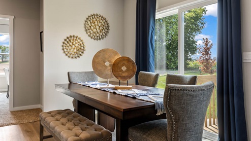 wood dining room table with grey chairs and glass sliding doors