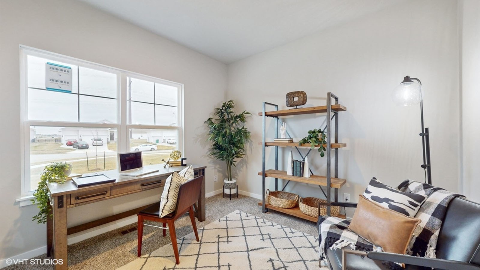 Second bedroom staged as an office with desk and chair