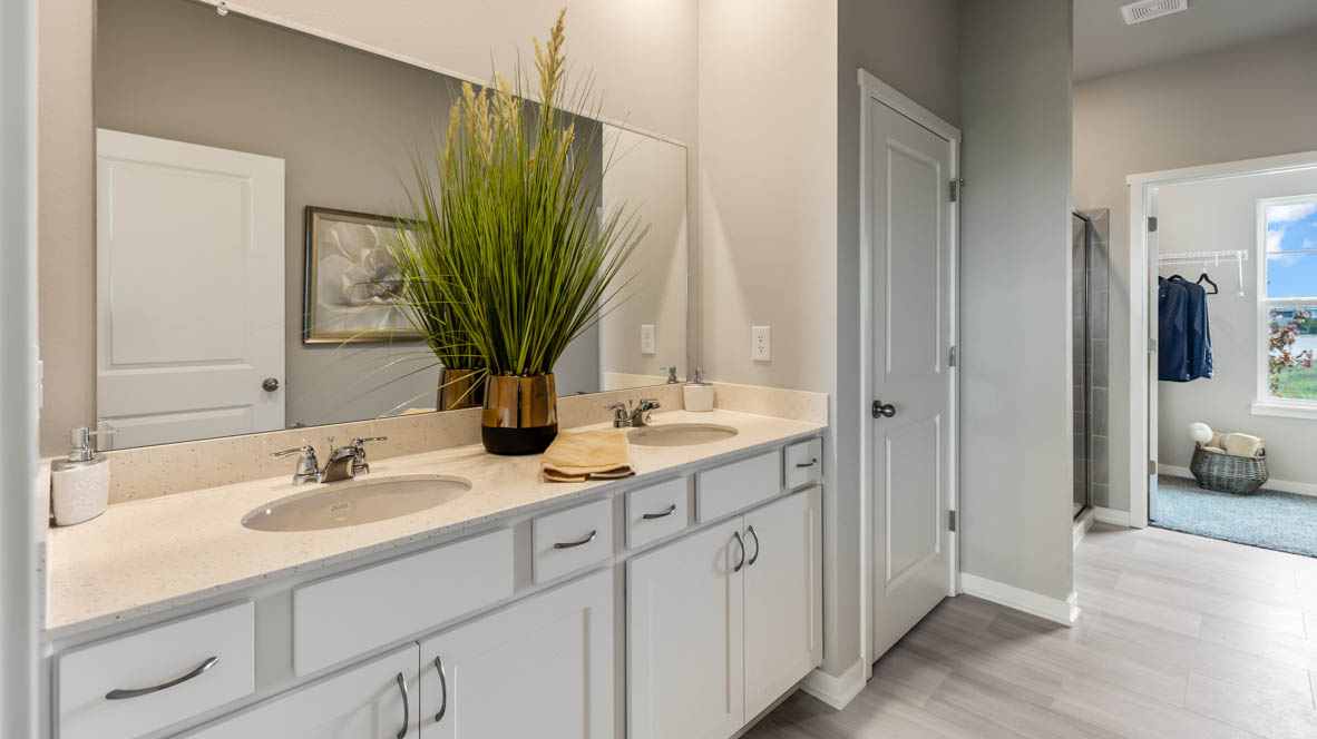 Primary bathroom with large mirror showing walk-in closet