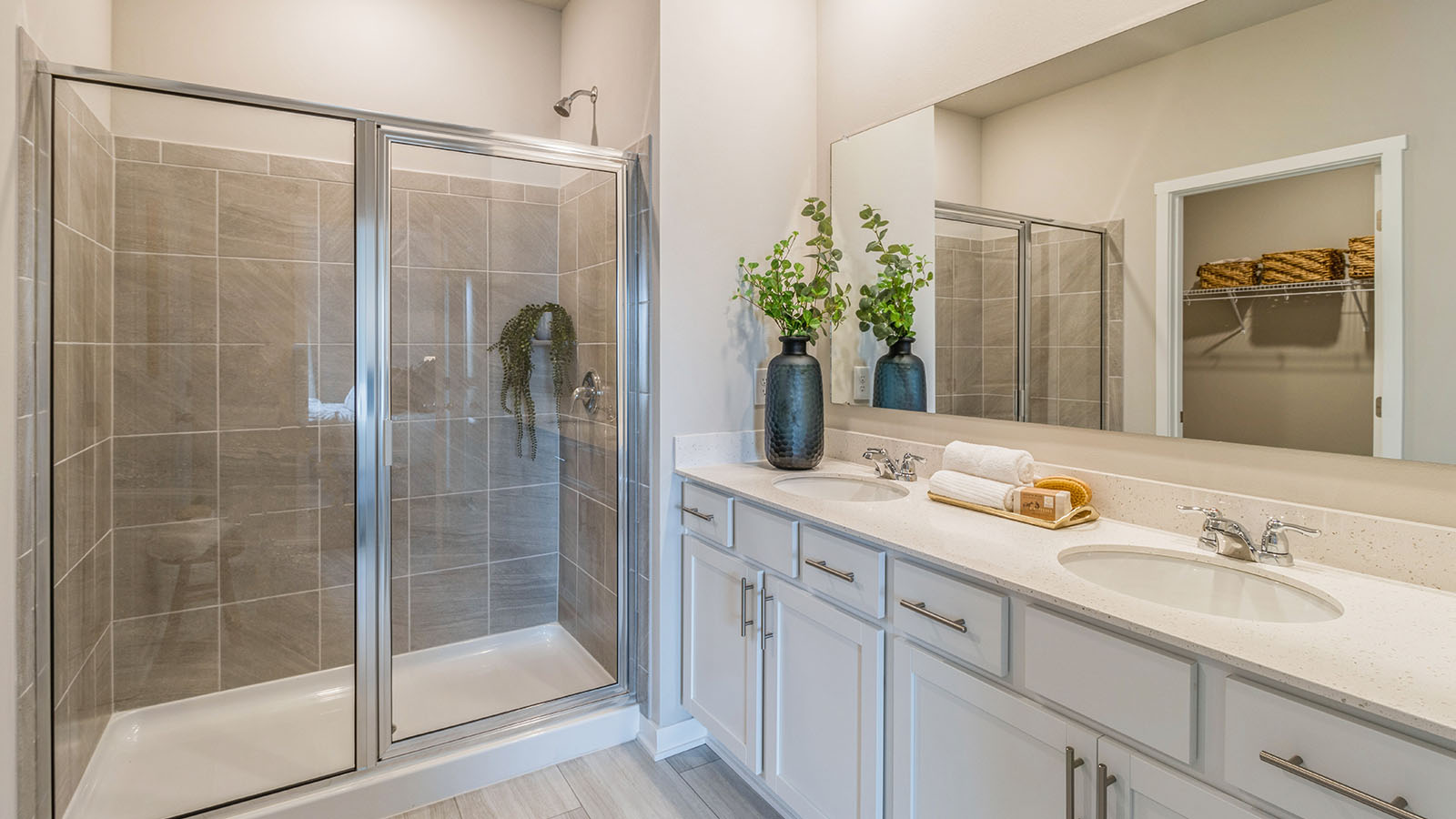 Primary bathroom with dual sinks and tile shower