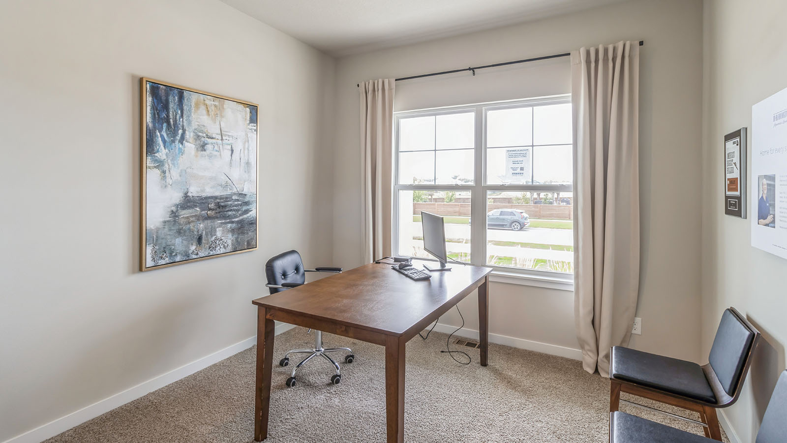 Second bedroom staged as office with desk and chairs