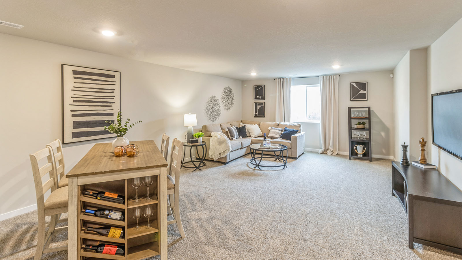 Finished basement with wood table and large tan couch
