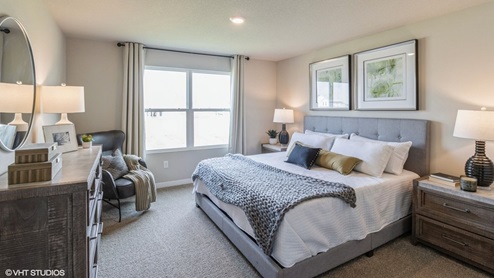 Spacious primary bedroom with large bed and brown nightstands