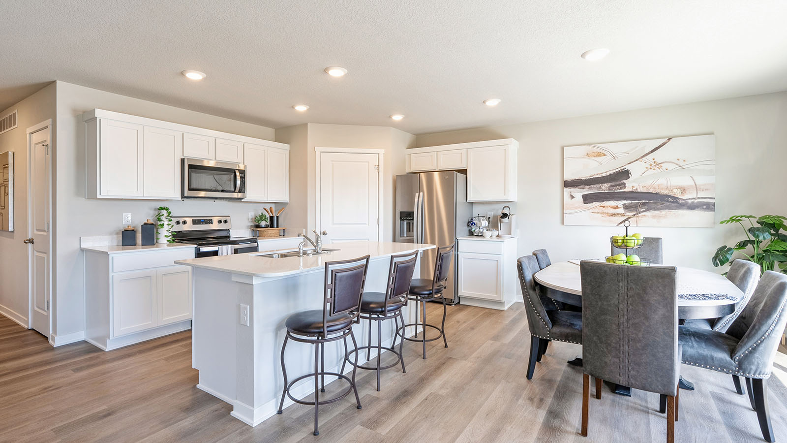 Bright dining area and kitchen with coffee table and stainless-steel appliances