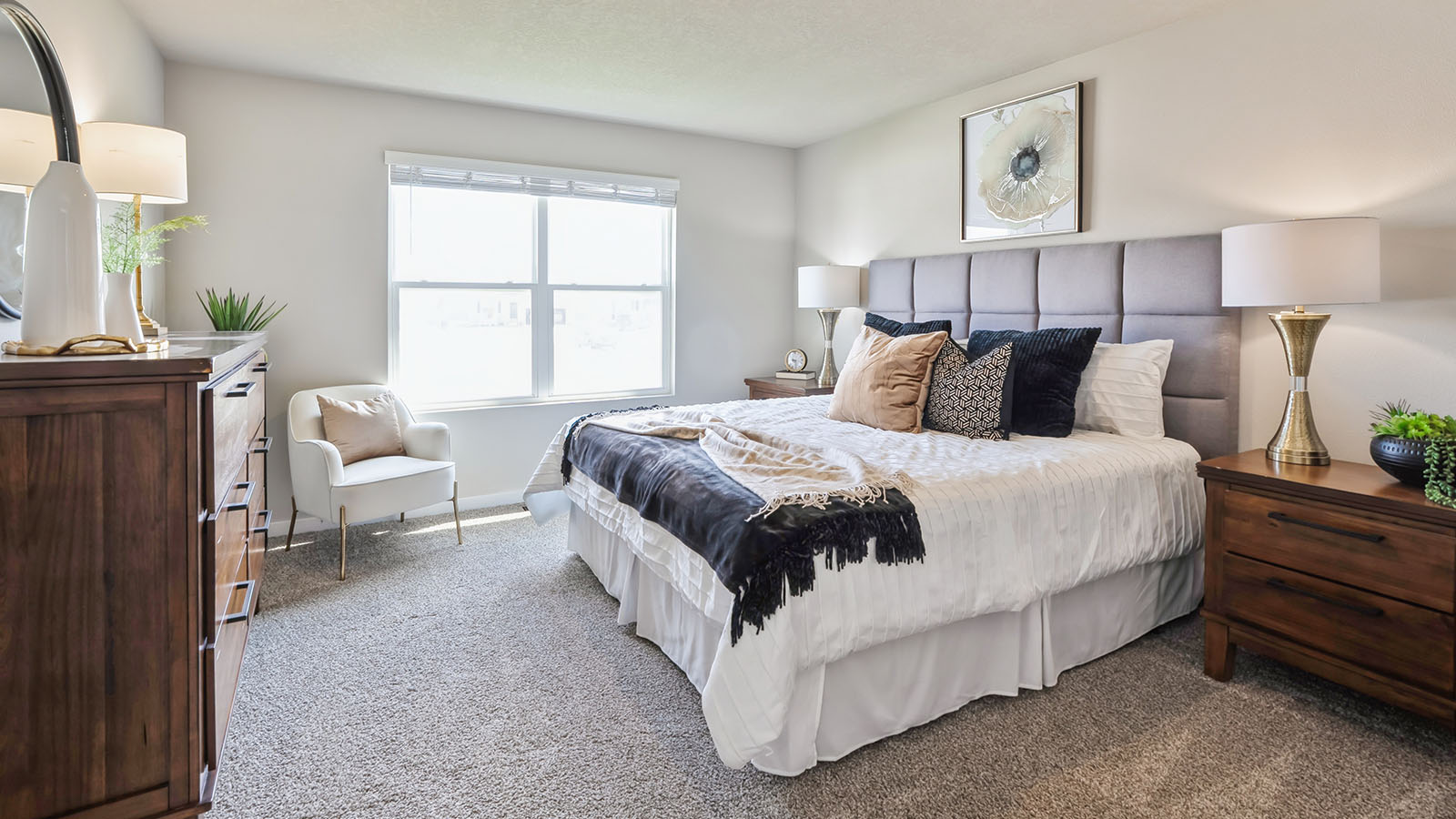Primary bedroom with large window and white bed
