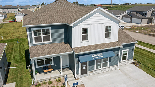Exterior photo of the Bellhaven in Canyon Landing with blue and white siding and covered front porch