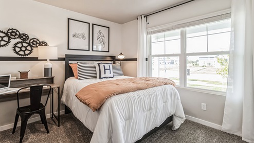 First bedroom with large window and desk