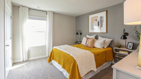 Fourth bedroom with grey accent wall and window
