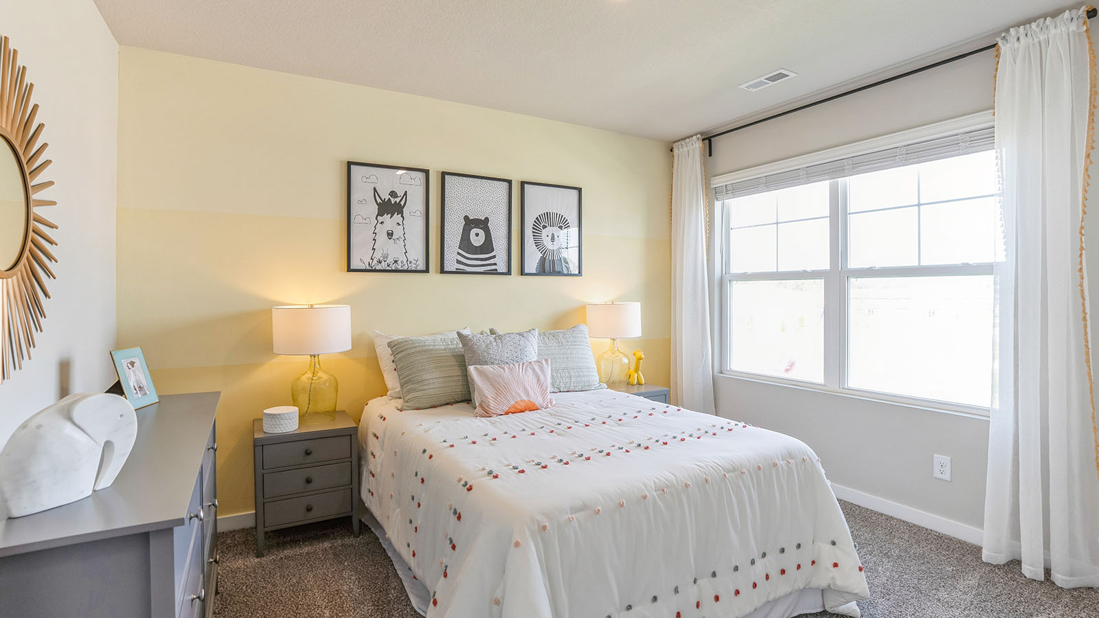Second bedroom with yellow accent wall and large window