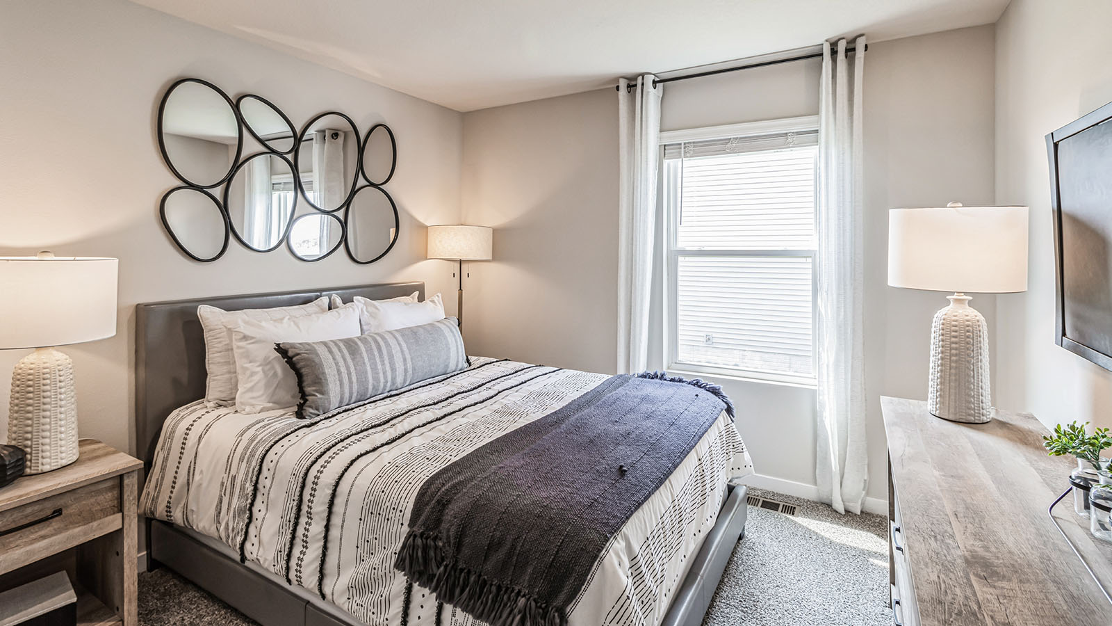 Second bedroom with colorful bed and small window