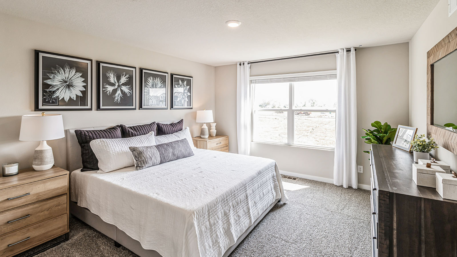 Primary bedroom with large window and white bed
