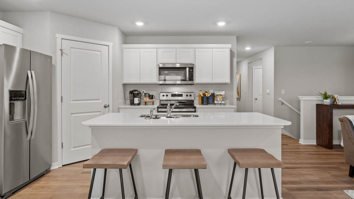Modern kitchen with island and three brown barstools