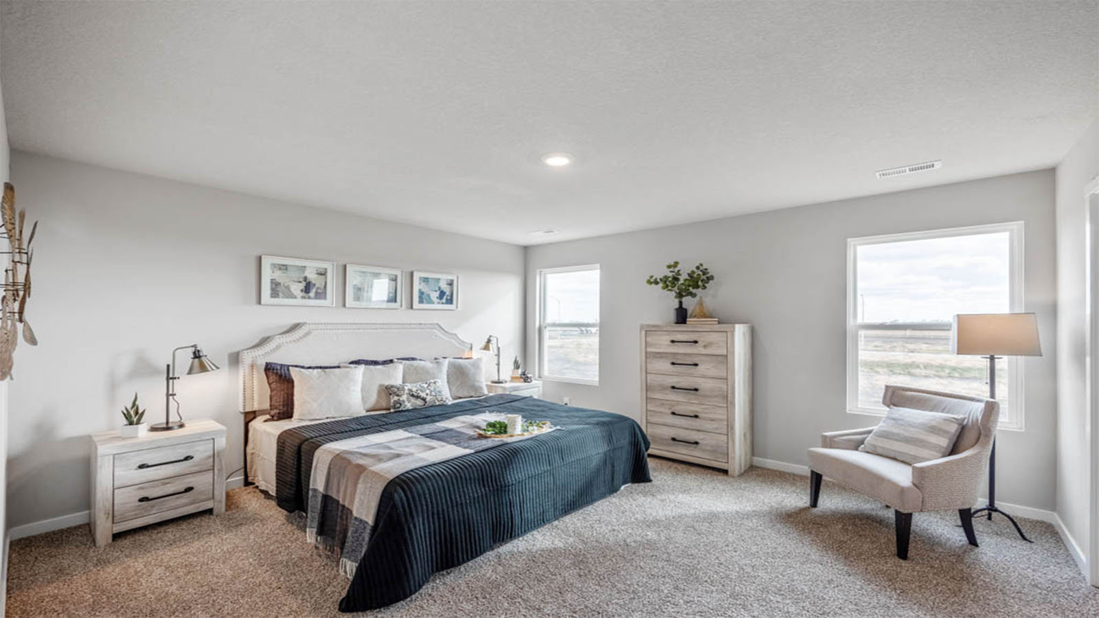 Spacious primary bedroom with large bed and seating area