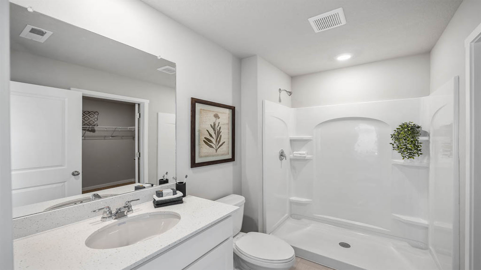 Primary bathroom with white cabinets and shower