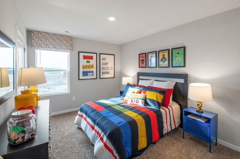 Second bedroom with colorful bed and blue nightstands